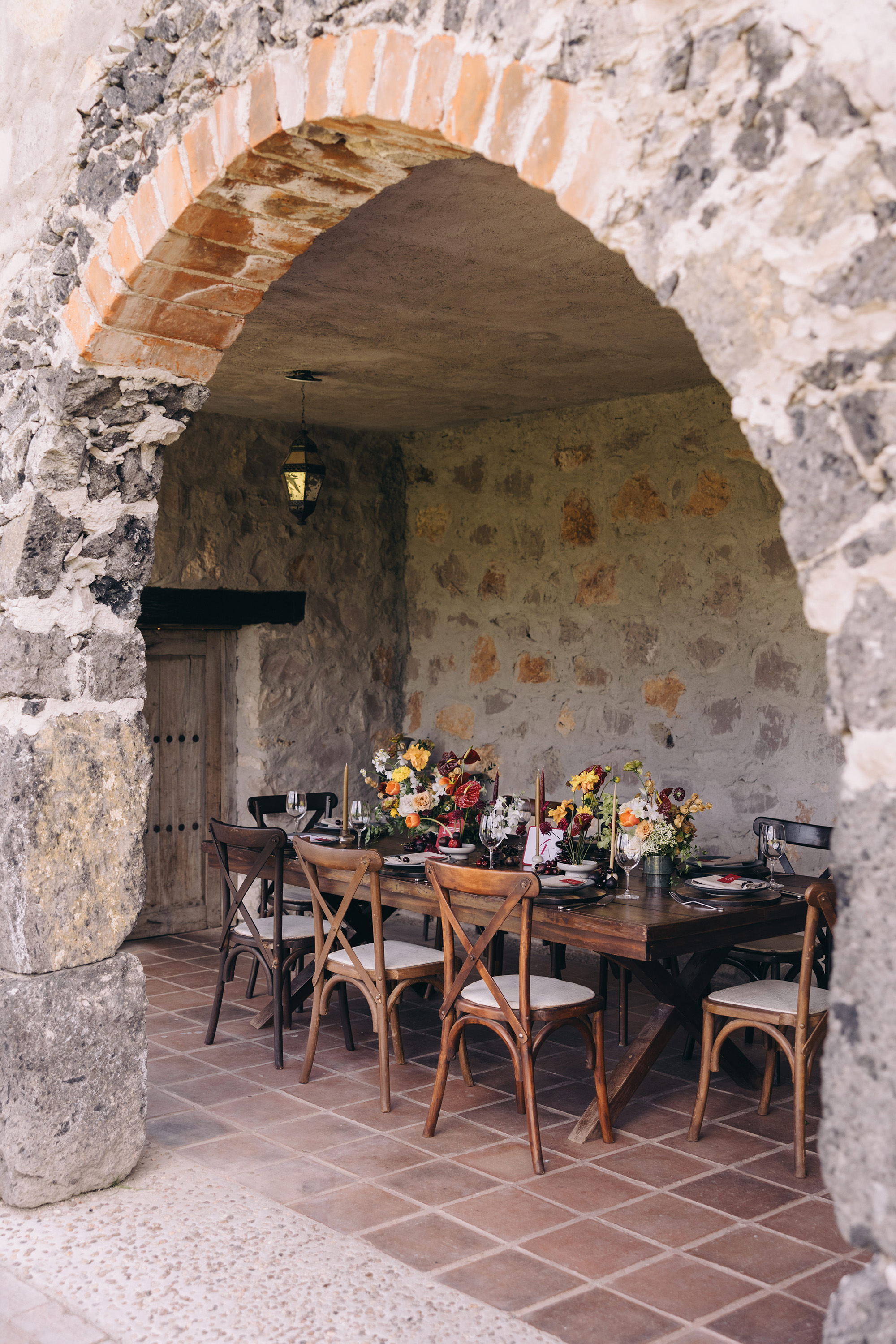 A set table beneath a stone arch at an event venue