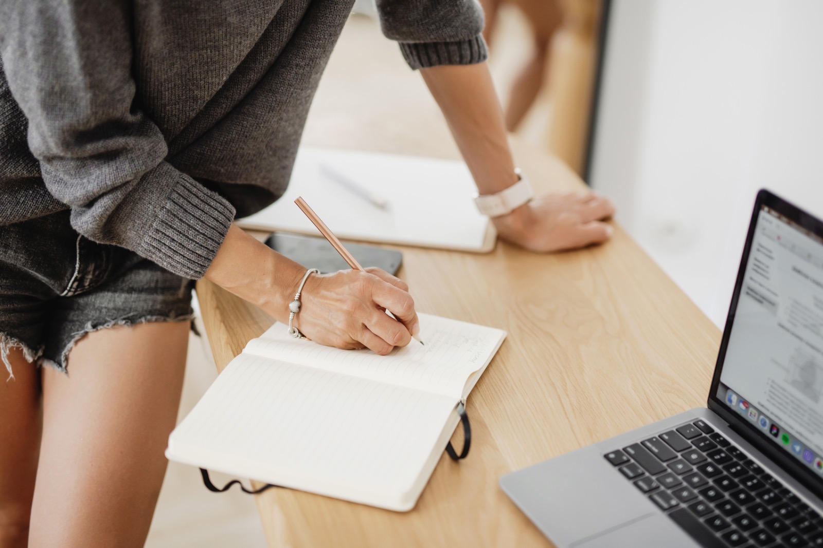 A desk with laptop and notebook, writing an email newsletter